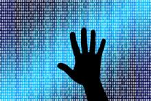 Hand silhouette reaching towards a blue cyber screen